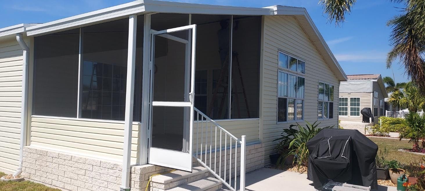 A mobile home with a screened in porch and stairs