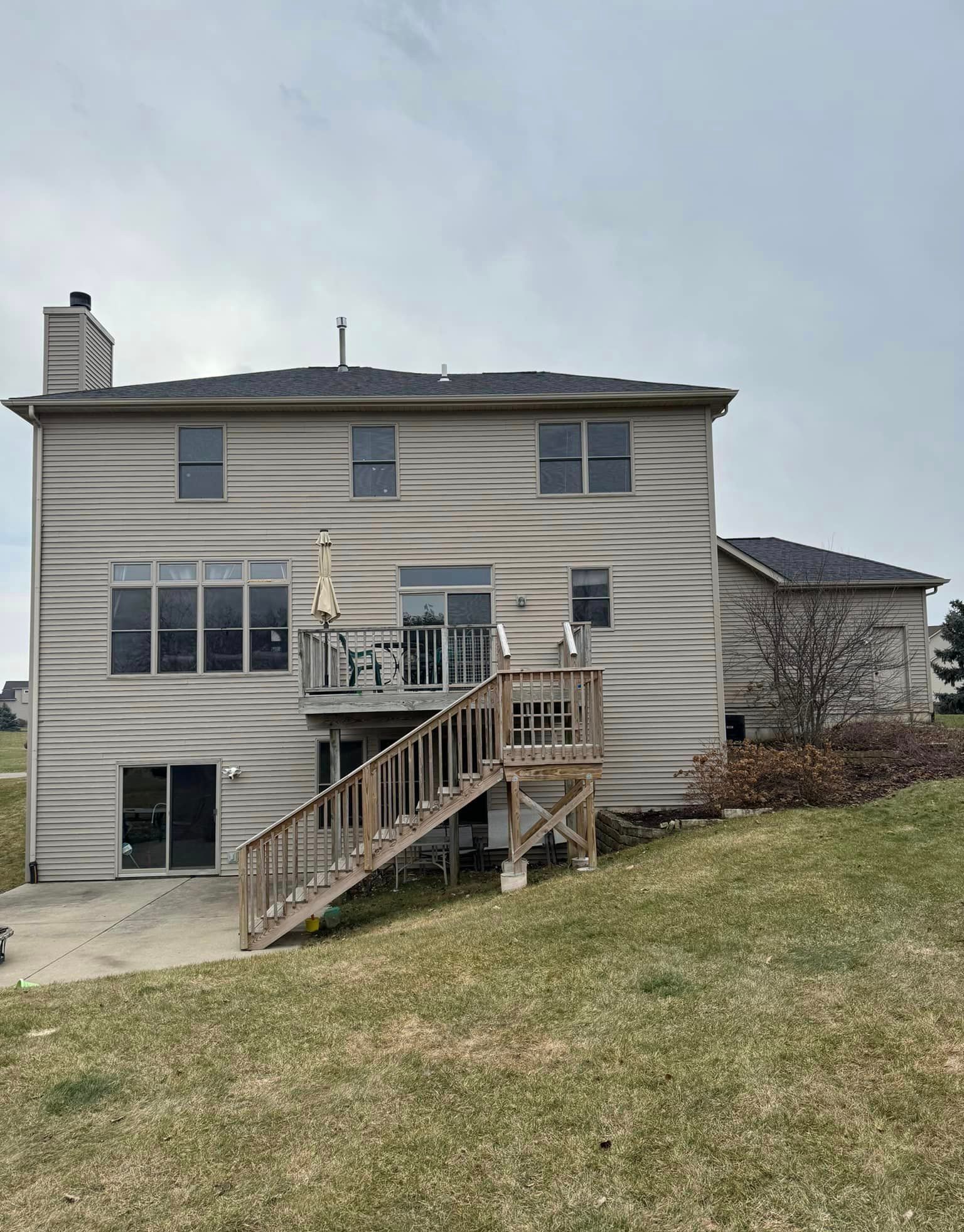 The back of a house with a large deck and stairs