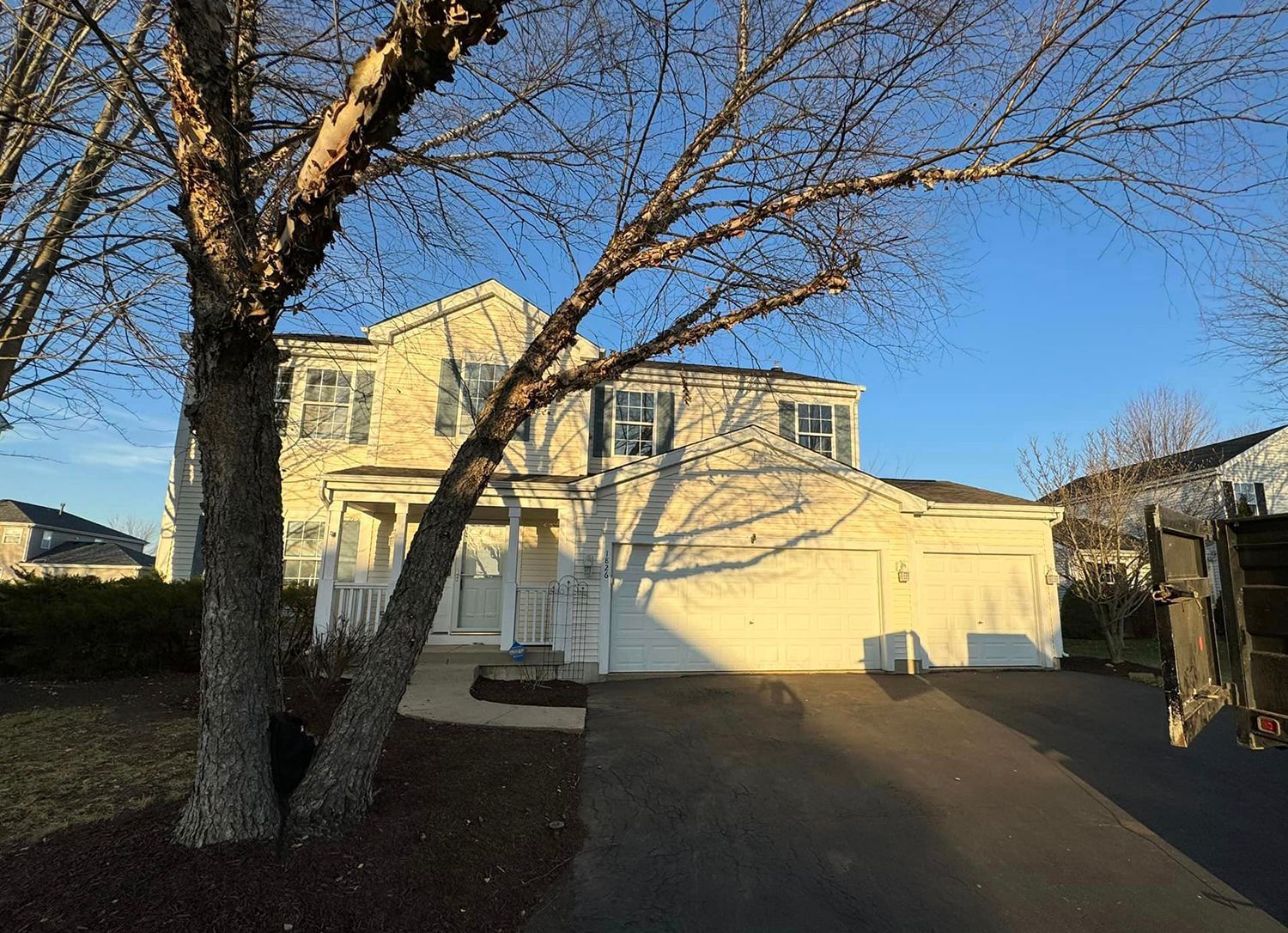 A large white house with a tree in front of it