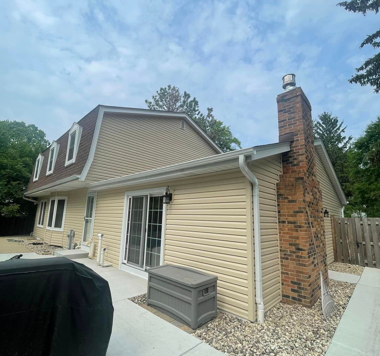 A house with a brick chimney on the side of it