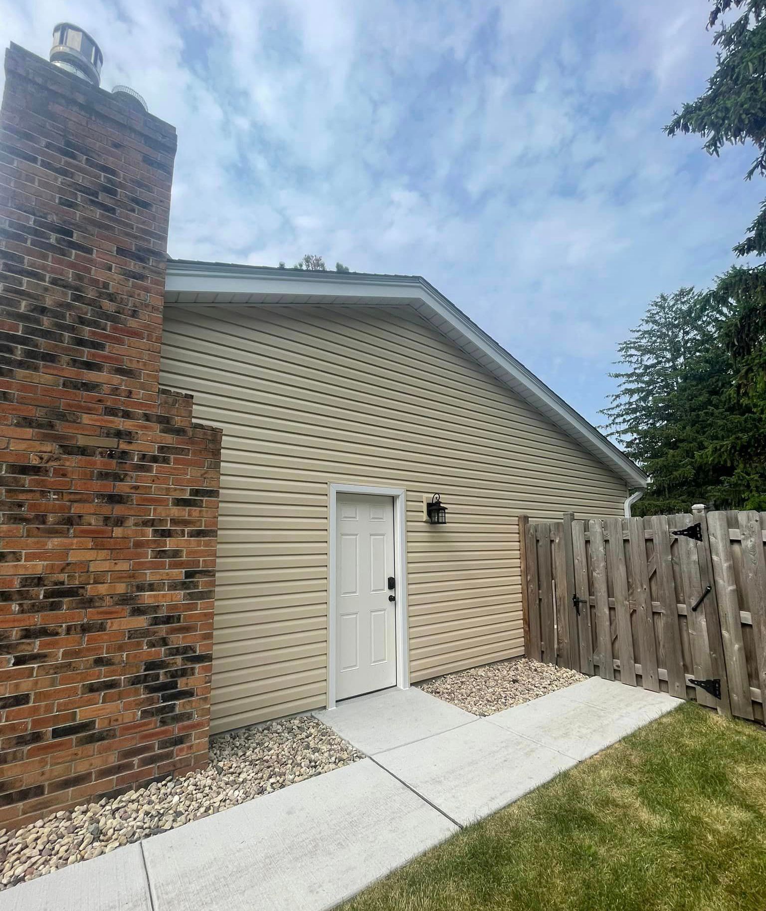 A house with a brick chimney and a white door