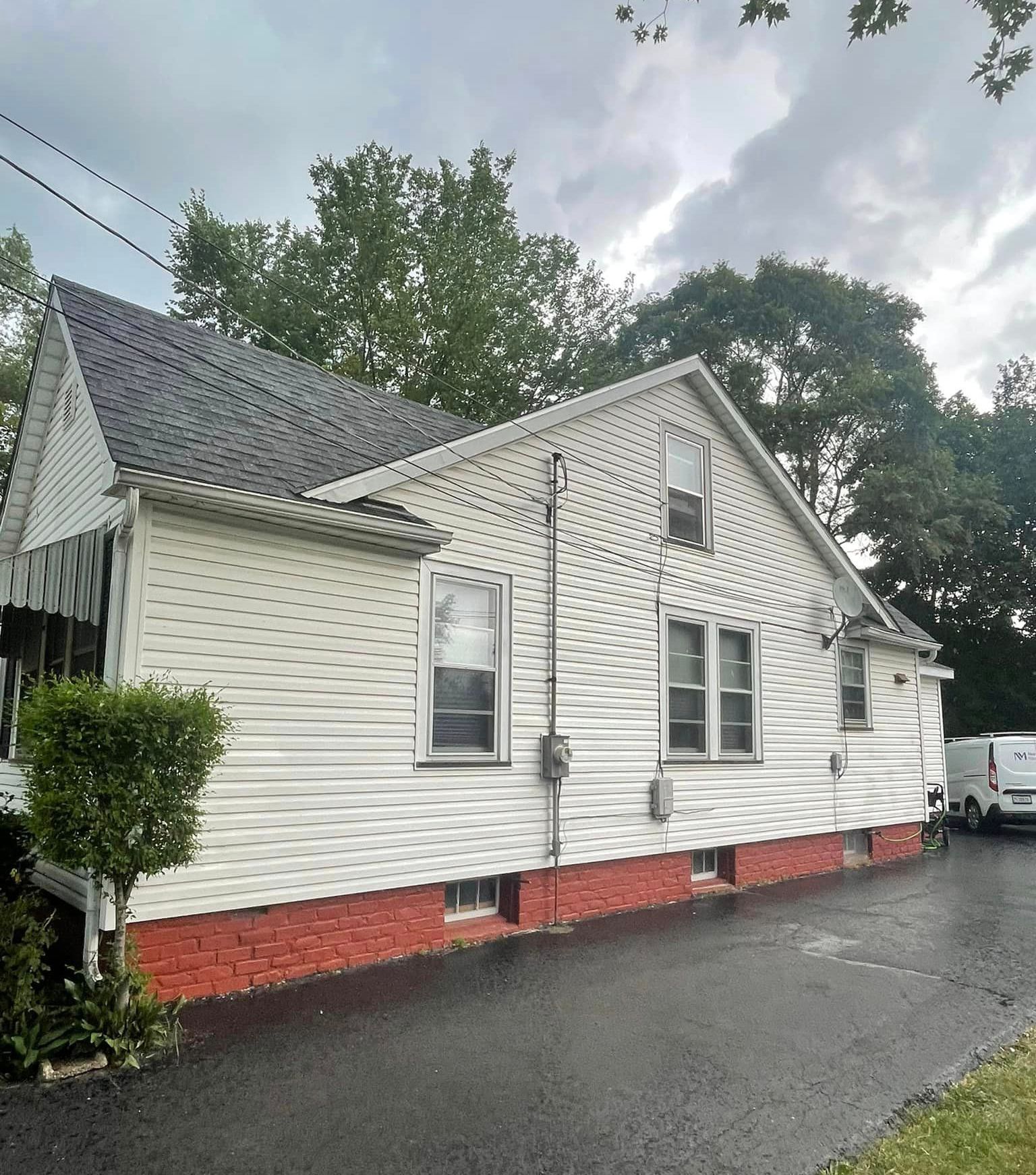A white house with red bricks and a black roof