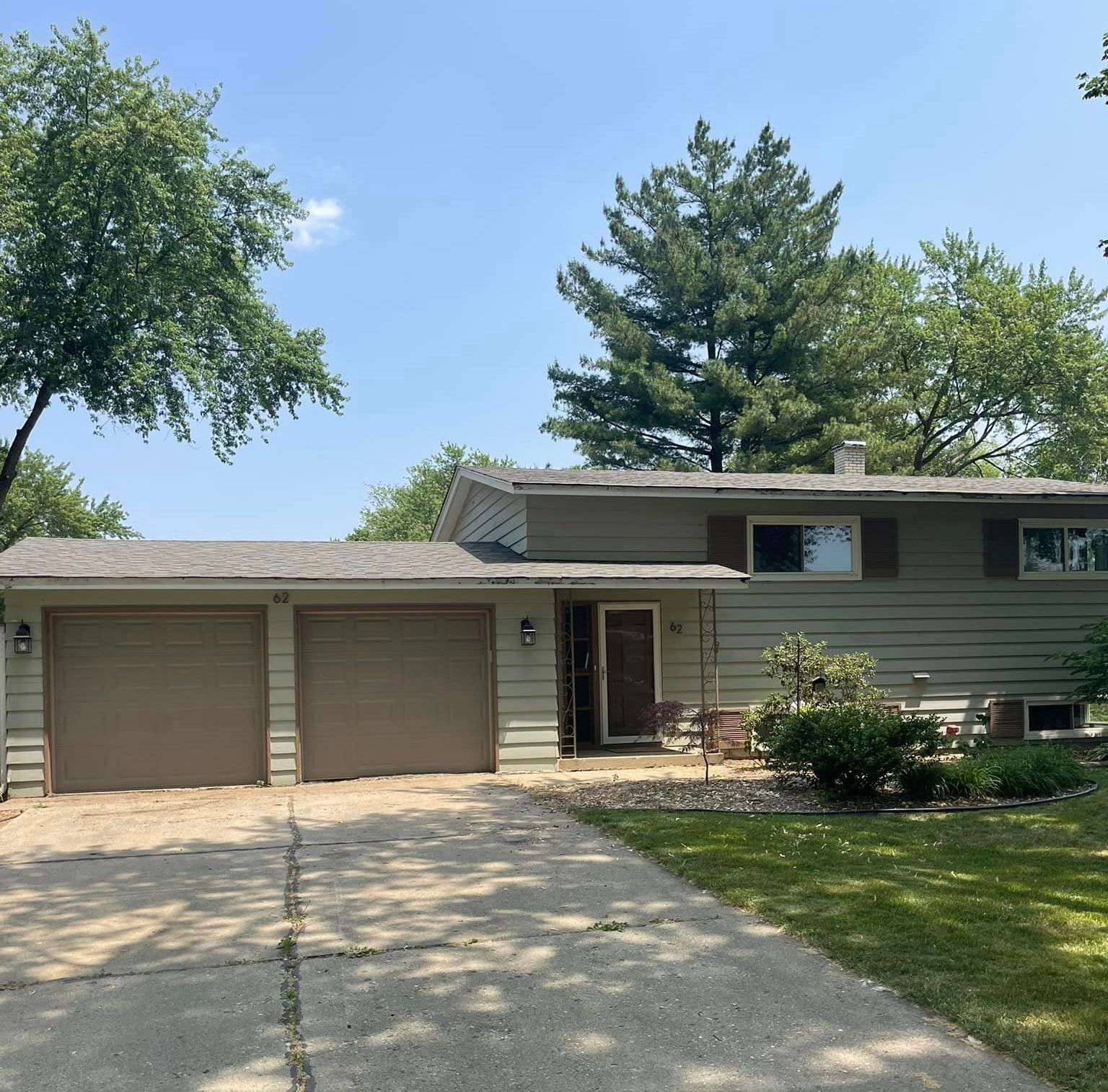 A house with three garage doors and a driveway