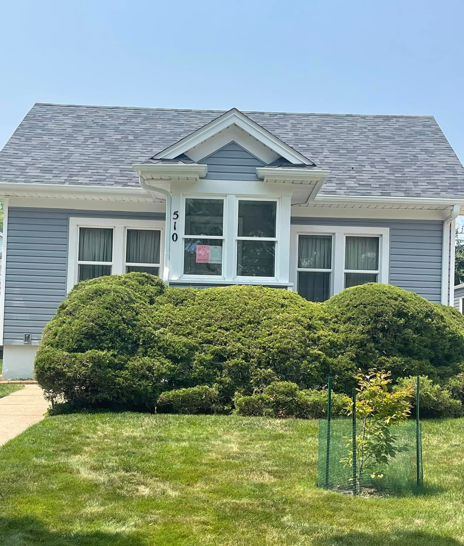 A small gray house with a gray roof and white trim