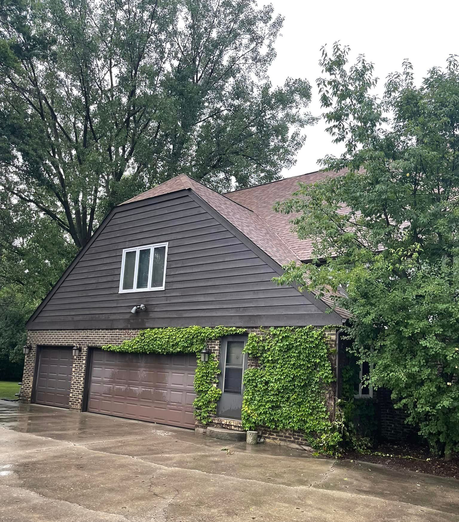 A house with a garage and a roof that is covered in ivy