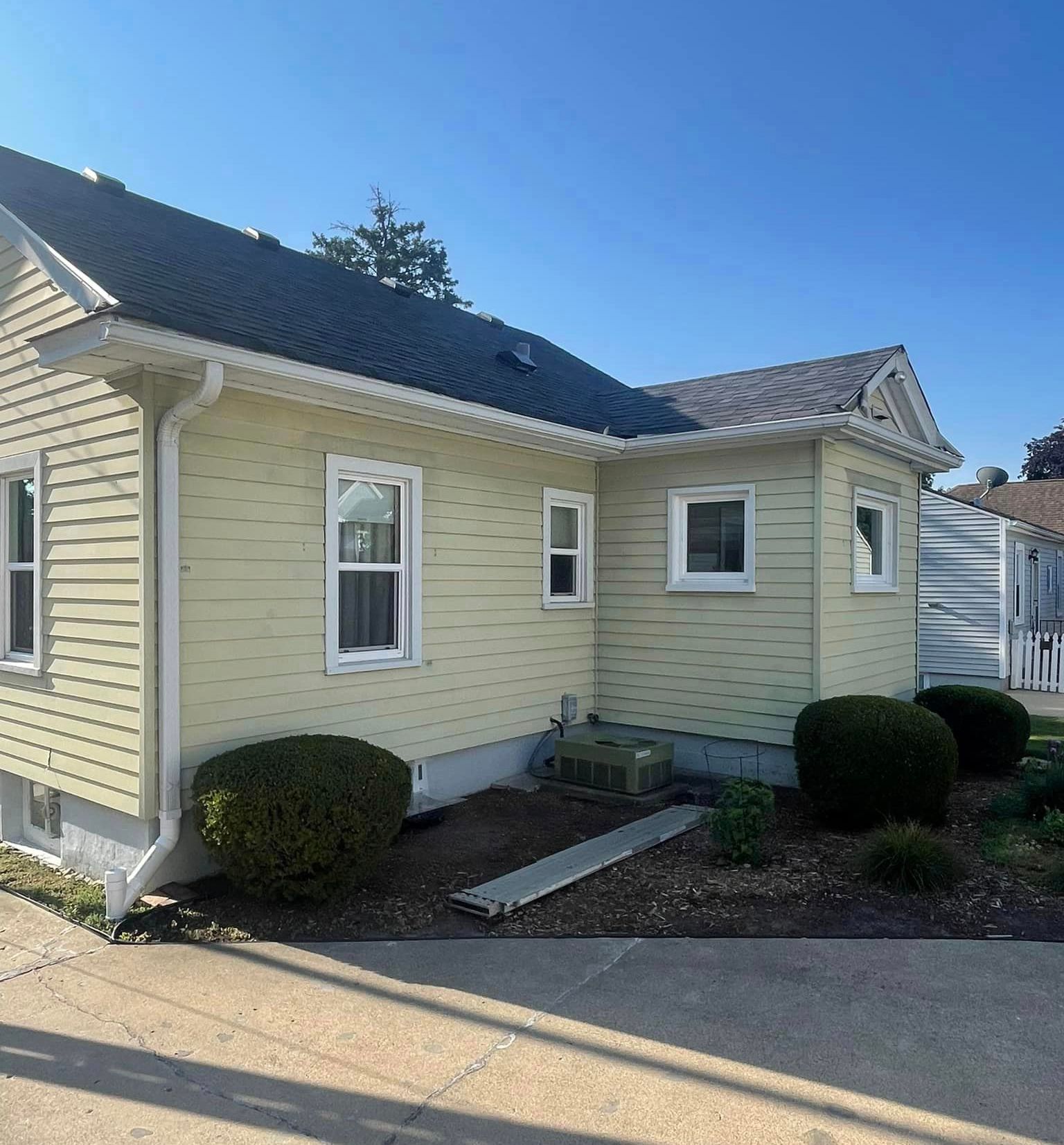 A small yellow house with a black roof