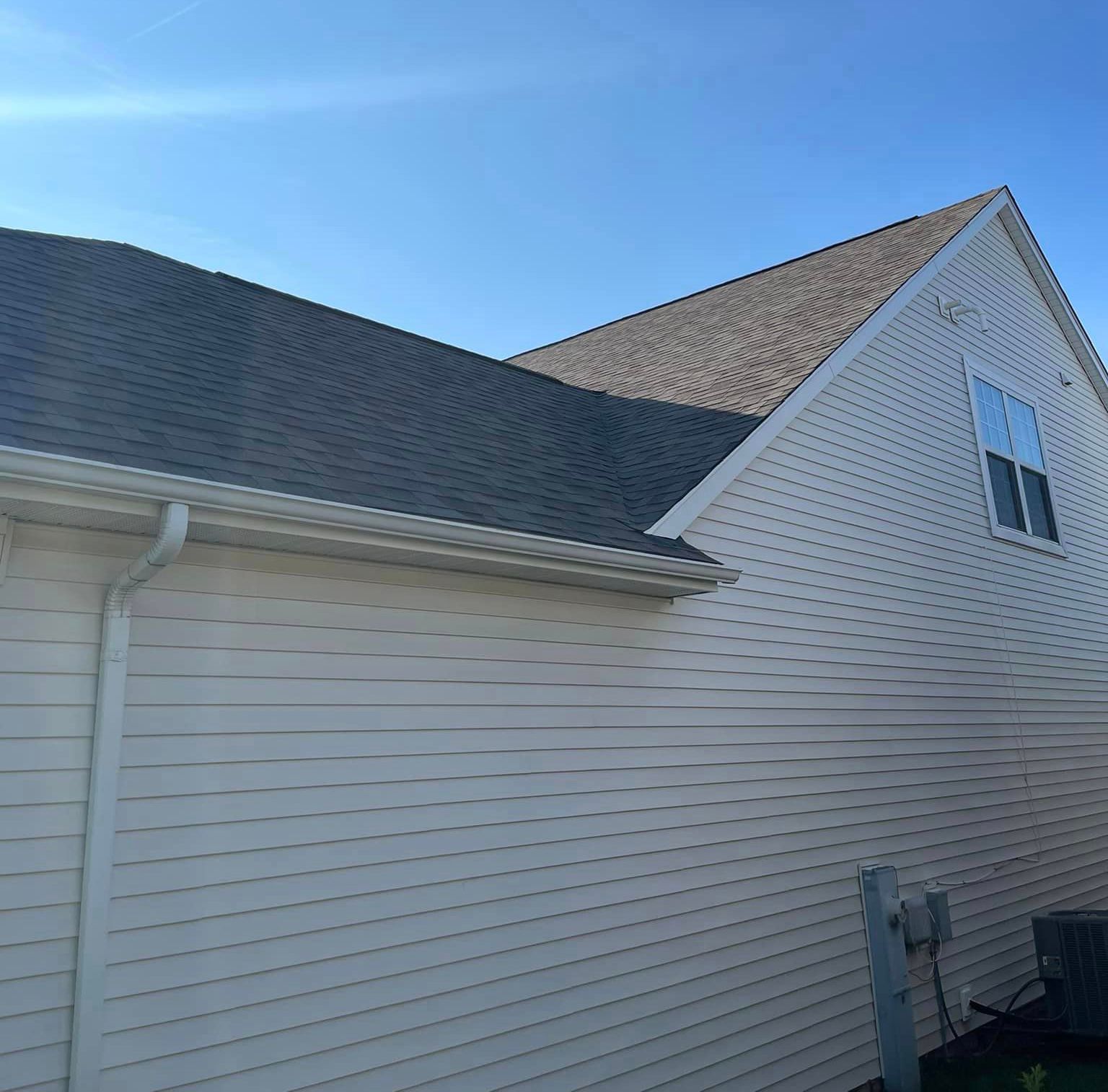 A white house with a black roof and a window
