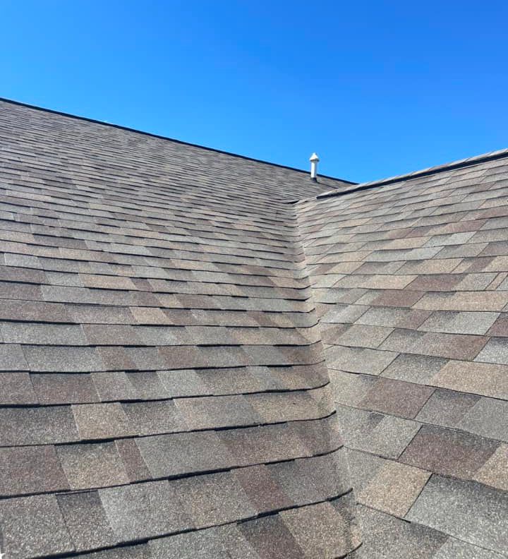 A close up of a roof with a blue sky in the background