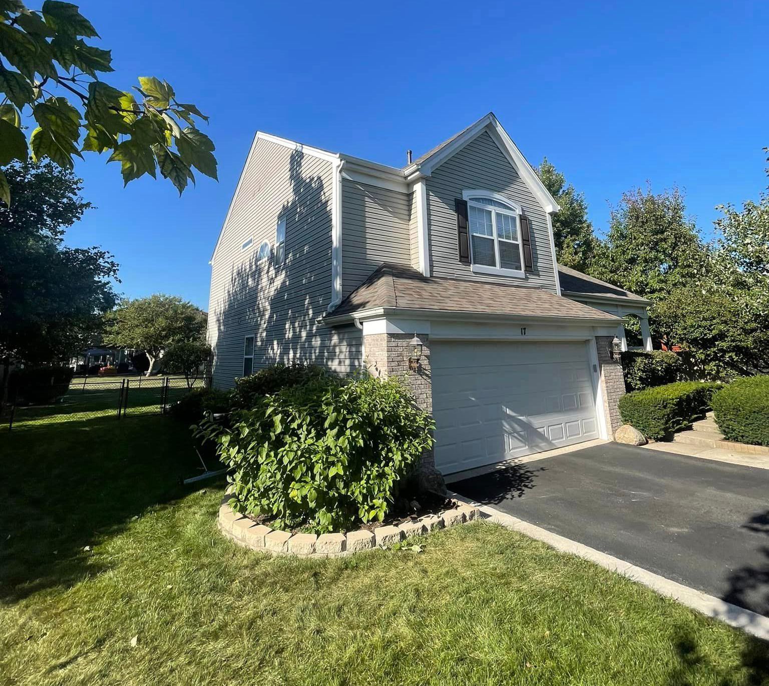 A house with a garage and a driveway in front of it