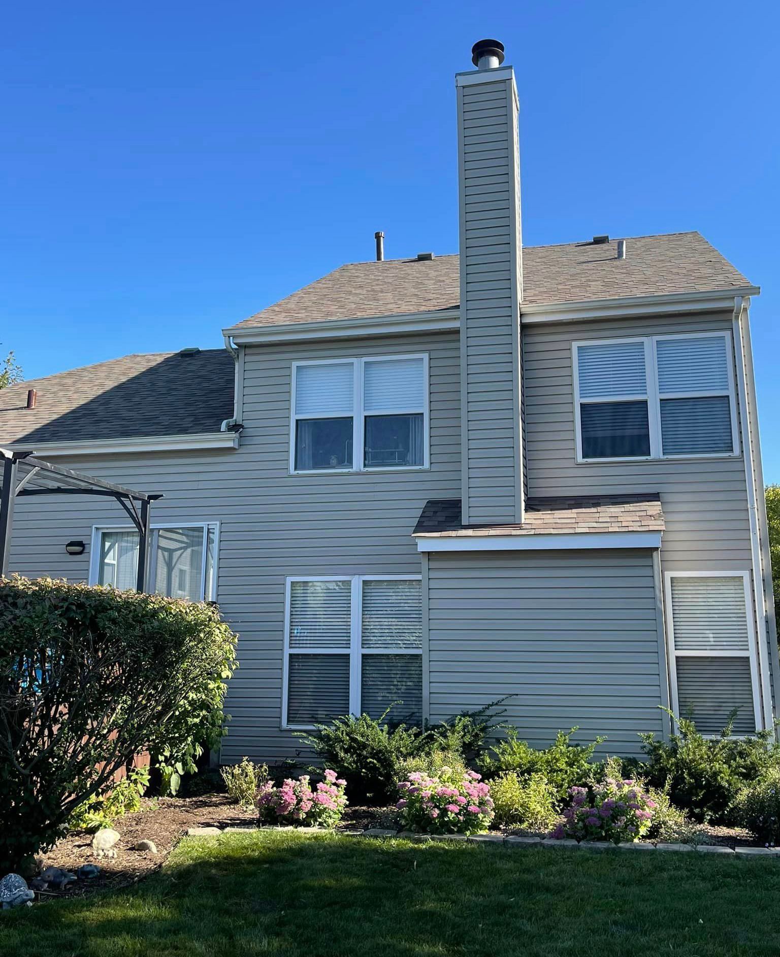The back of a house with a chimney and many windows