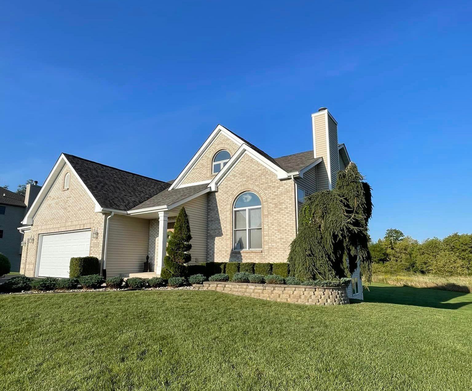 A large brick house with a large lawn in front of it
