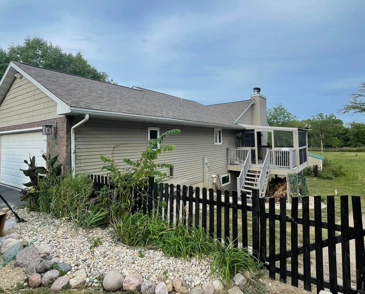 A house with a black picket fence in front of it