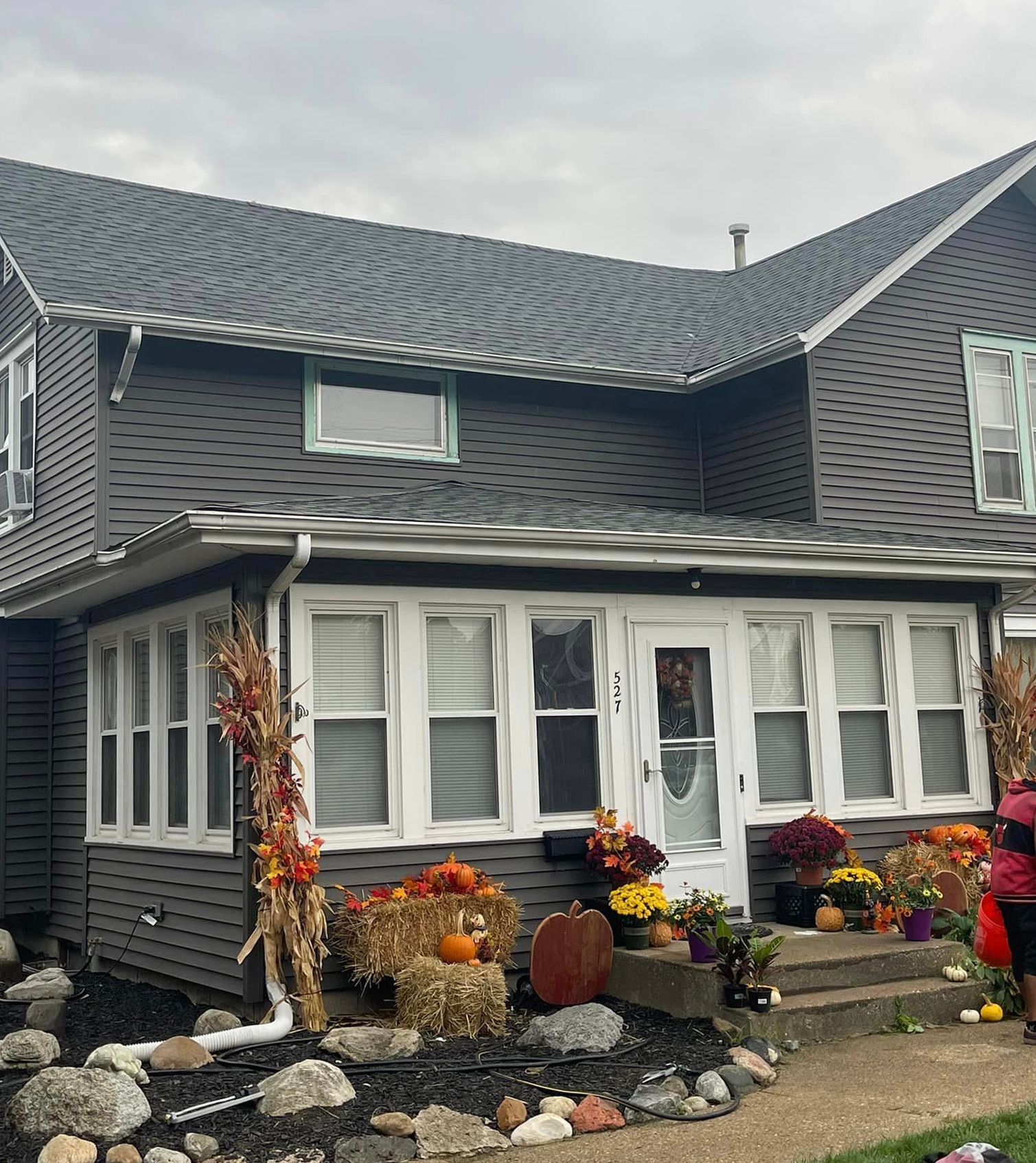 A house decorated for halloween with pumpkins and flowers
