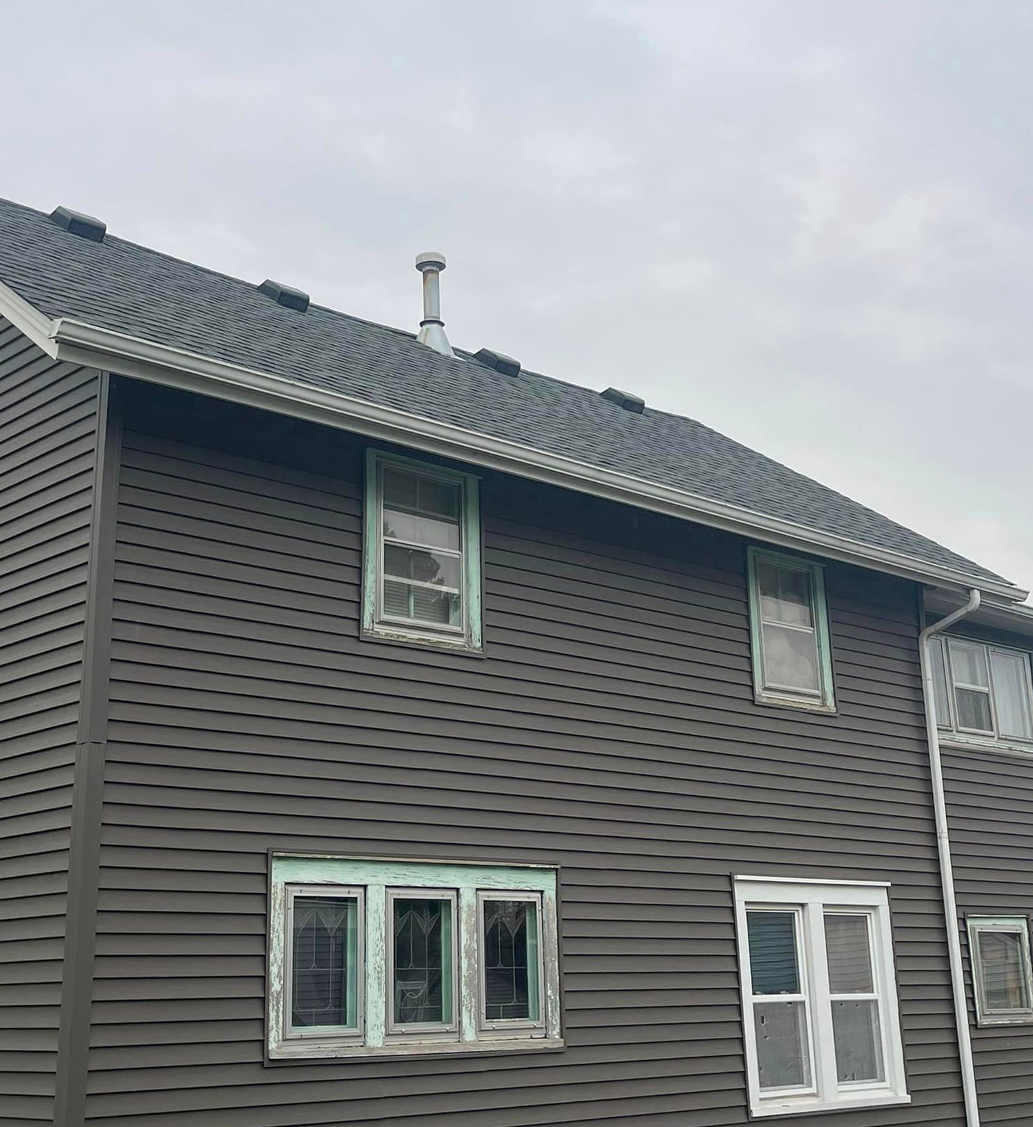 A large house with a lot of windows and a chimney on the roof