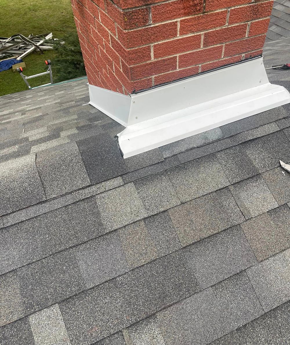 A brick chimney is sitting on top of a roof