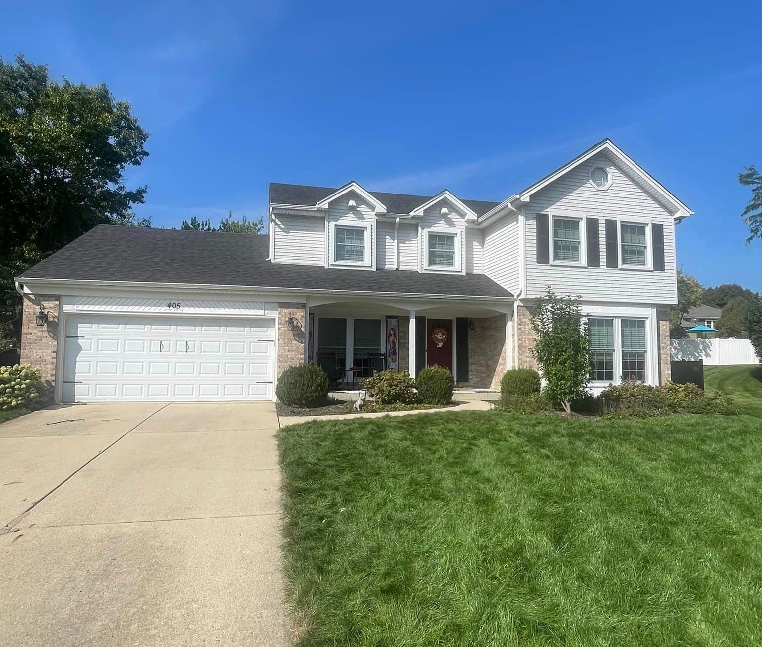 A large white house with a lush green lawn in front of it