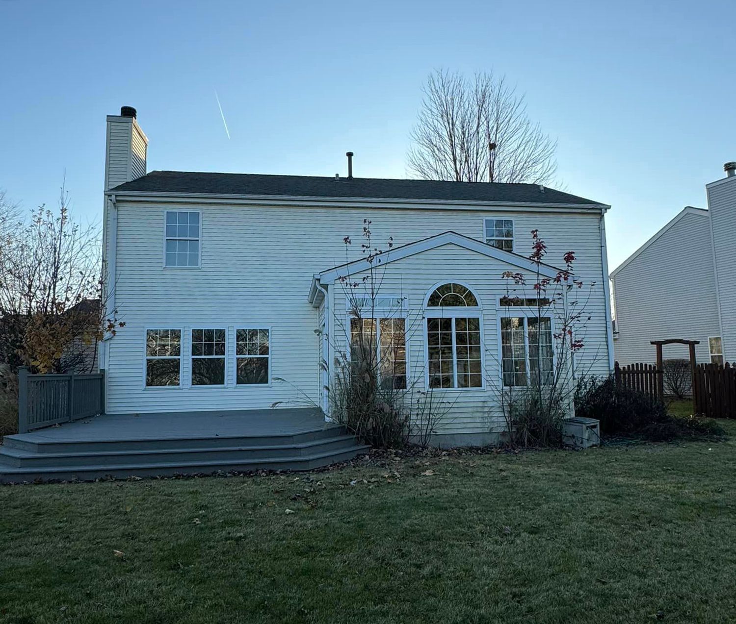 The back of a white house with a large deck