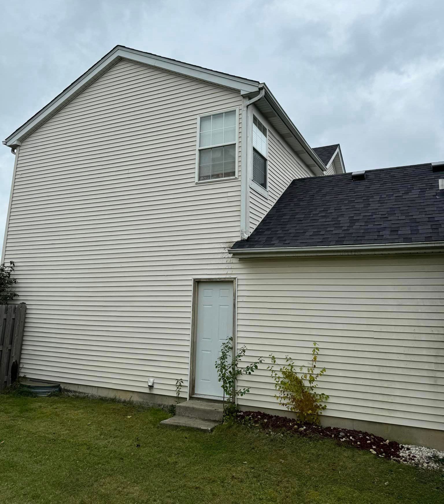 A white house with a black roof and a white door