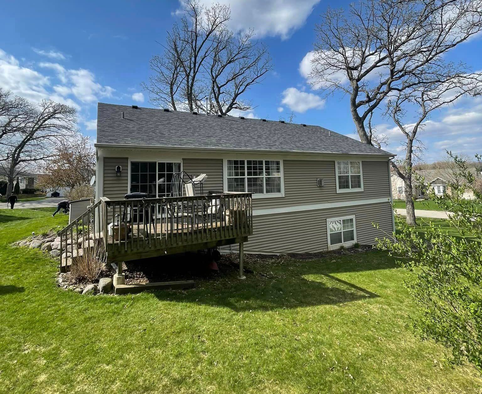 A small house with a large deck in the backyard