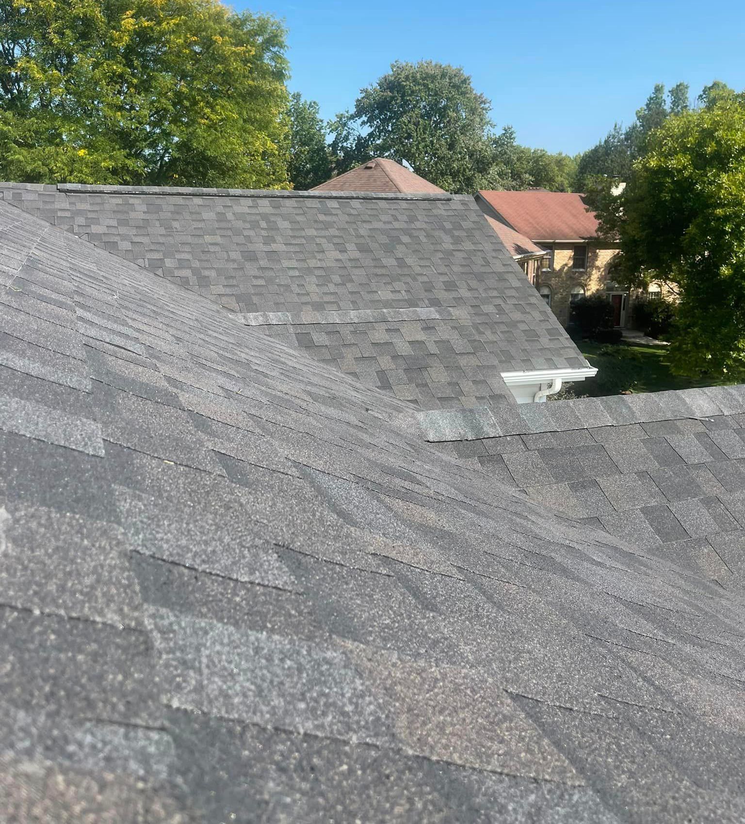 A close up of a roof with trees in the background