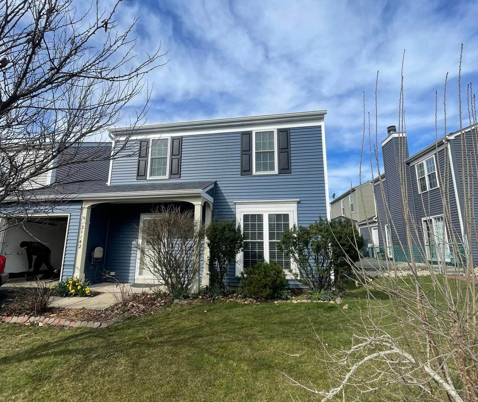 A blue house with a roof that is being built