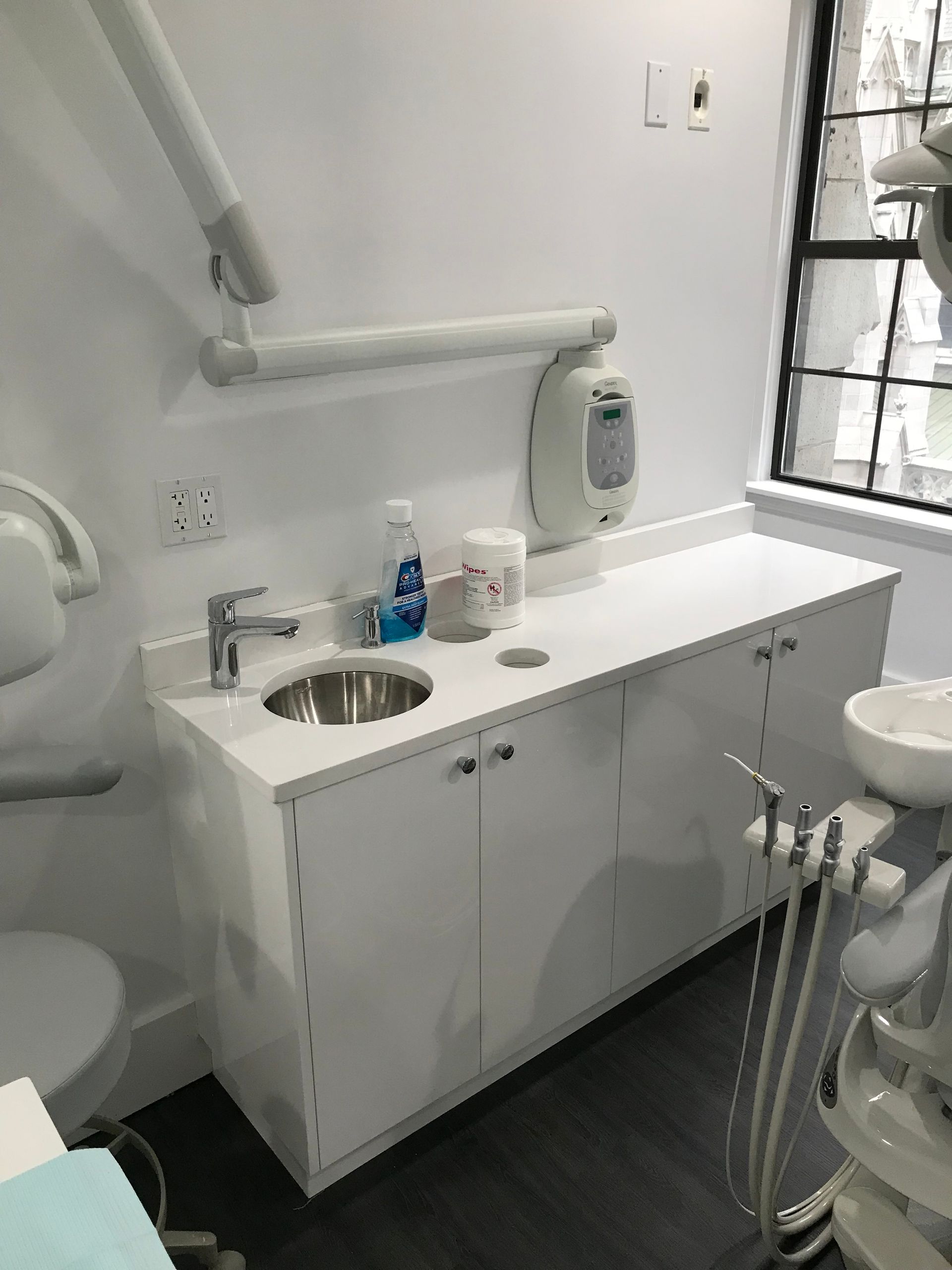 white dental cabinet with a round sink and waste disposal