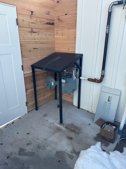 A gas meter is sitting on a table outside of a building