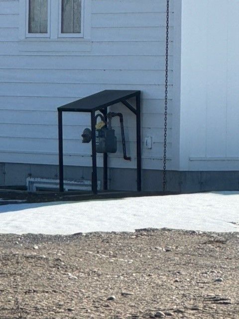 A white house with a black canopy on the side