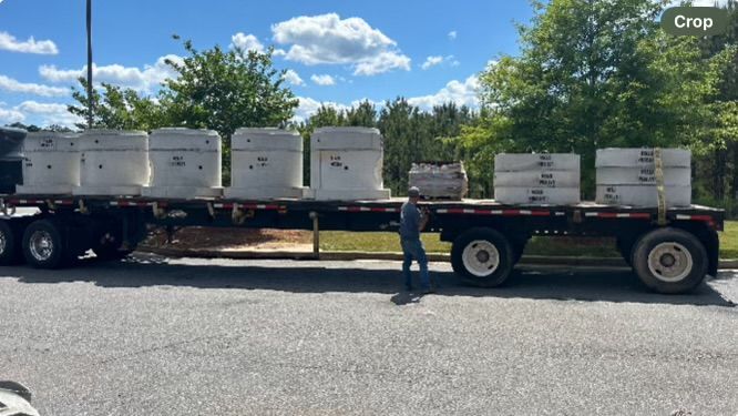A man is pushing a semi truck full of concrete blocks