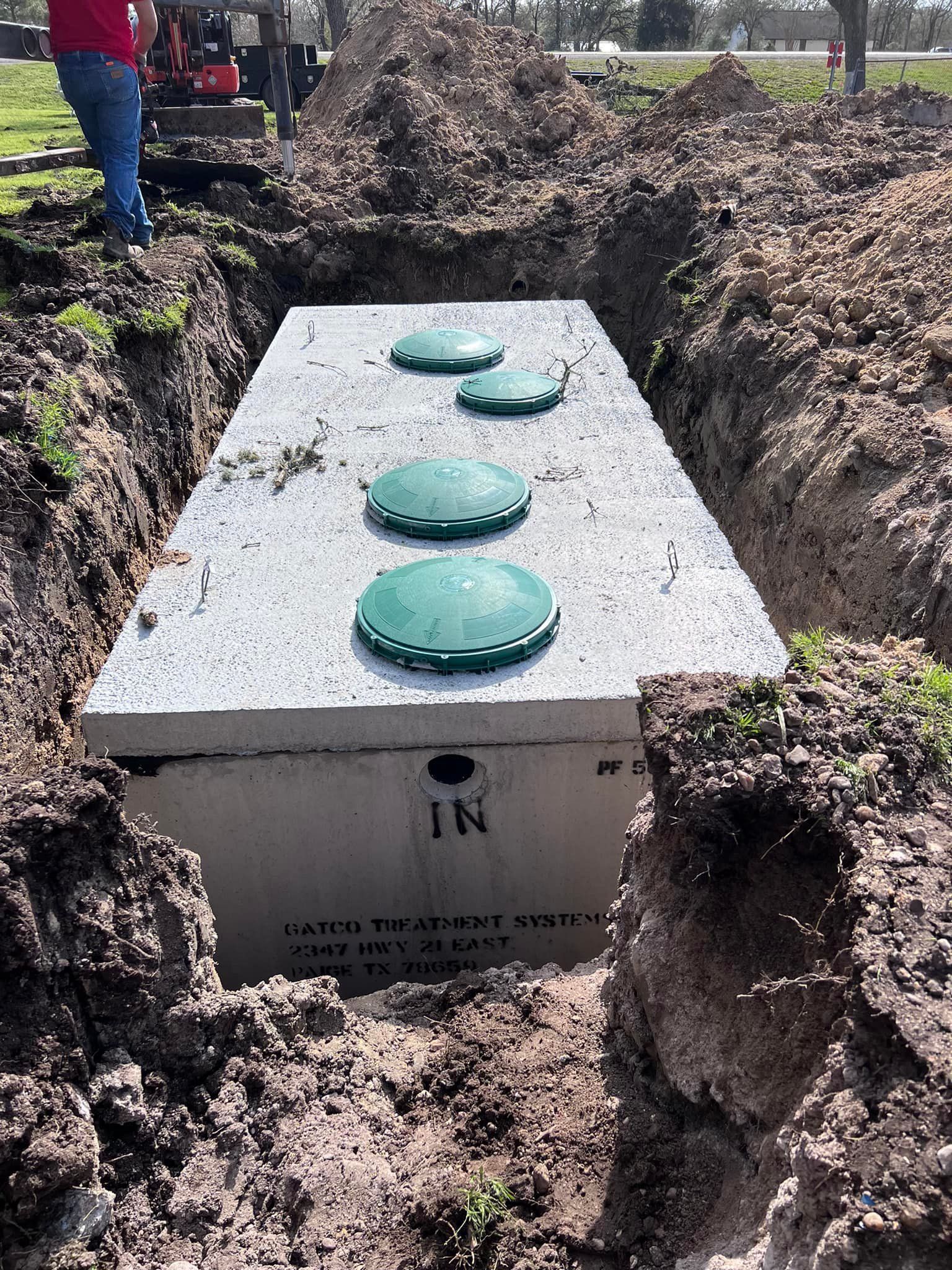 A septic tank is being installed in a hole in the ground.