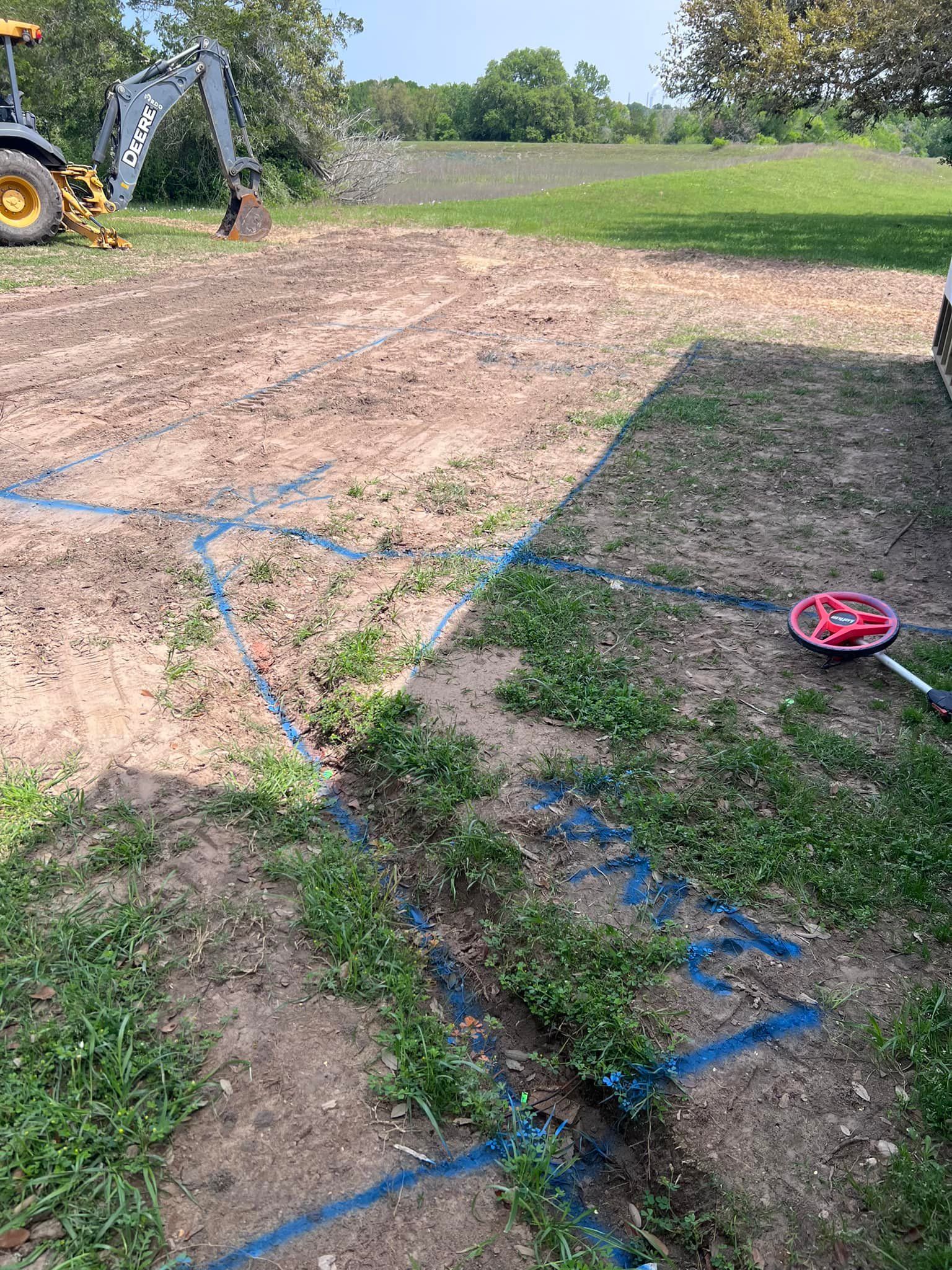 A tractor is digging a hole in the ground in a yard.