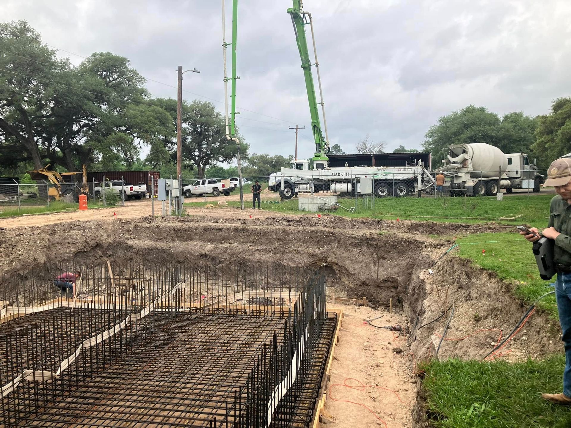 A man is standing in a field looking at a construction site.