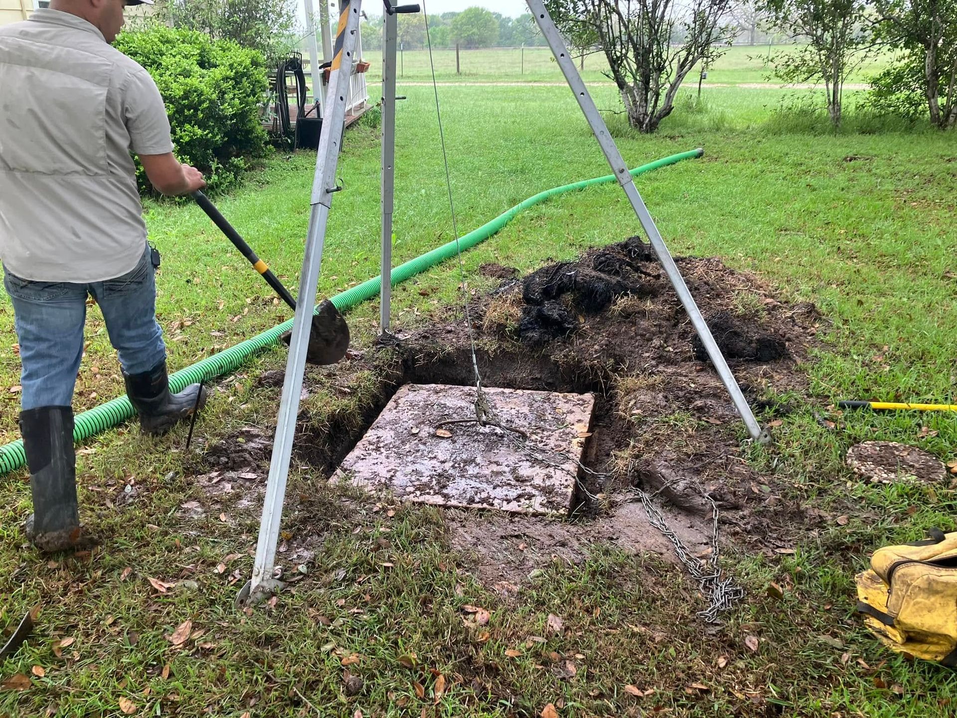 A man is digging a hole in the grass with a shovel.