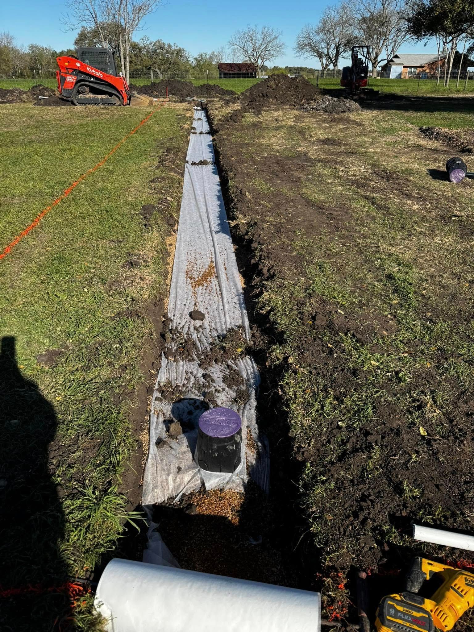 A drainage system is being installed in a field.