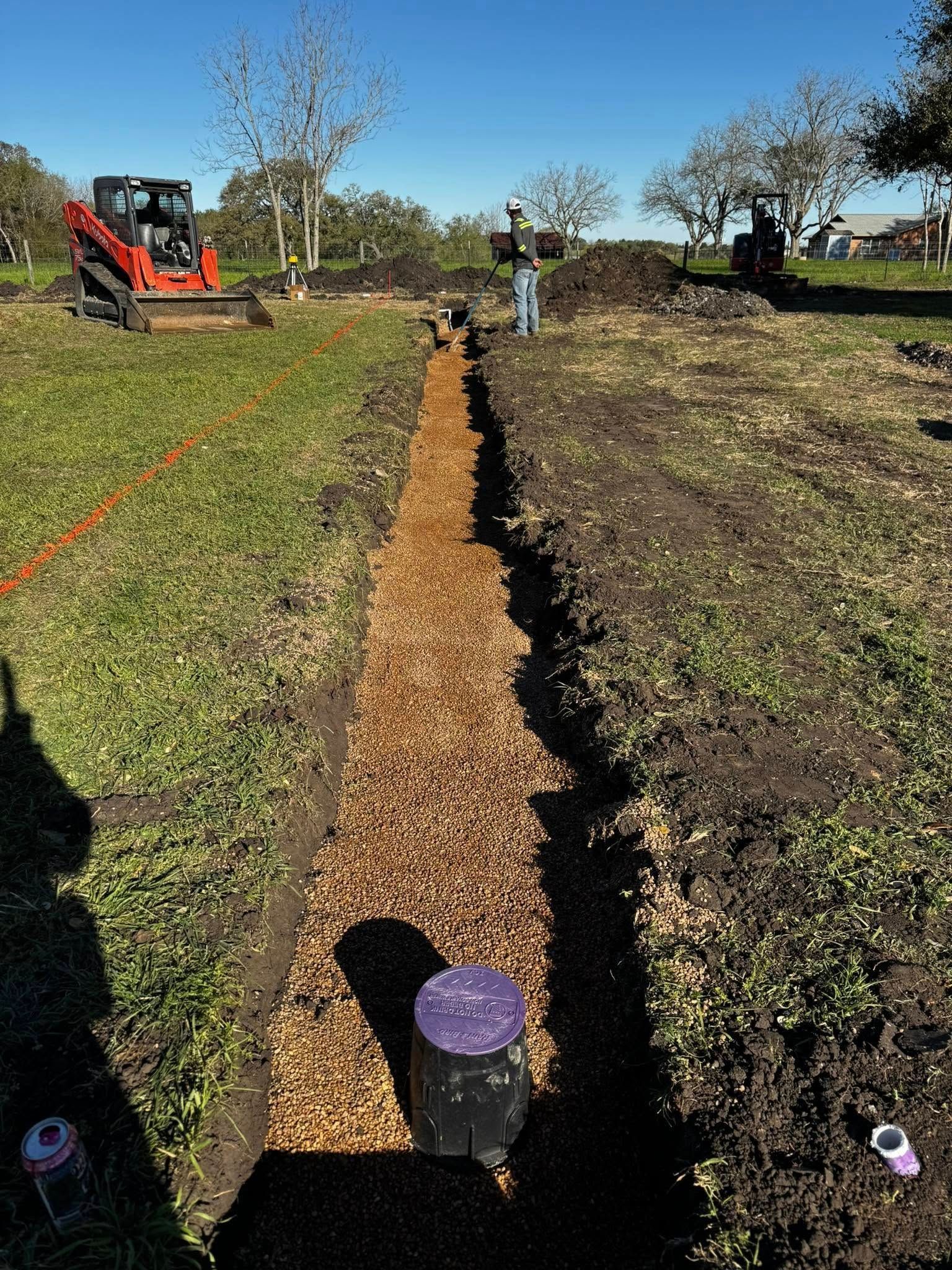 A bulldozer is digging a hole in the ground in a field.