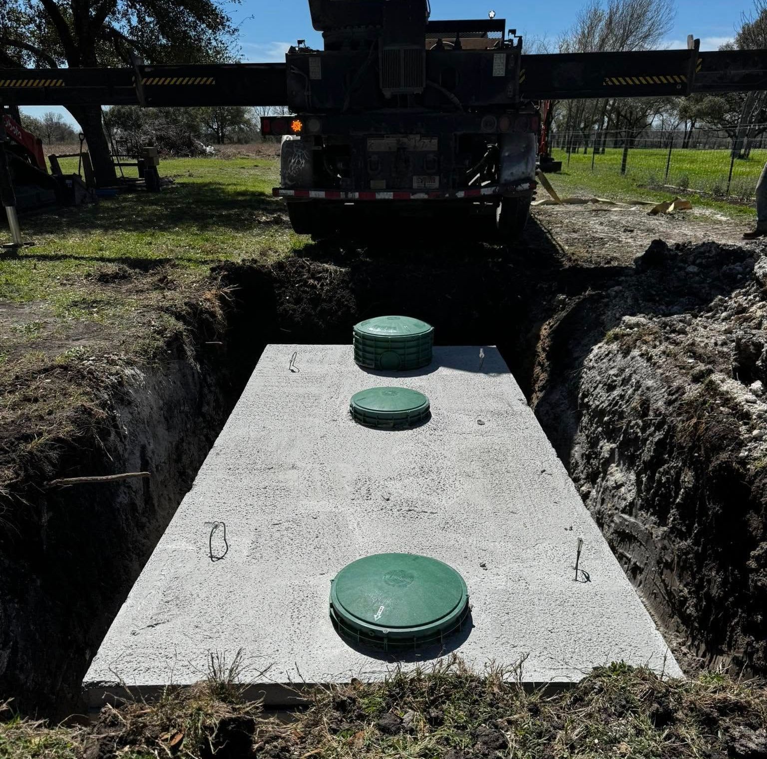 A septic tank is being installed in a hole in the ground