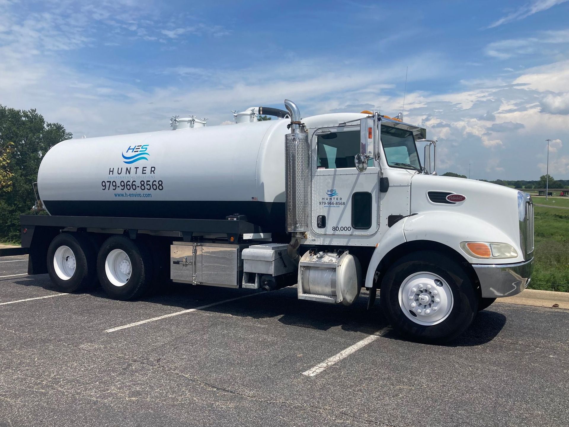 A white water truck is parked in a parking lot.