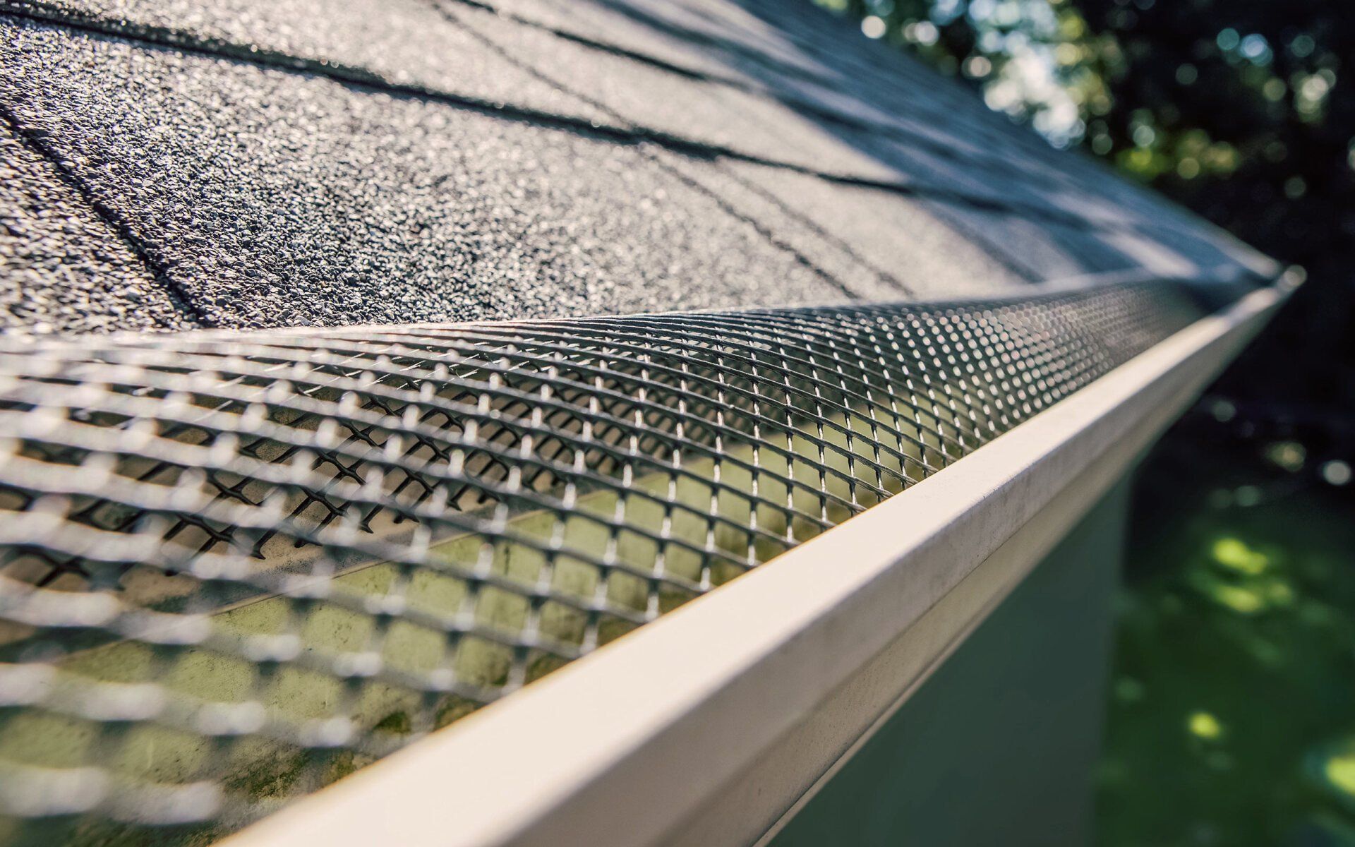 Close-up of a roof gutter with a mesh guard, protecting against debris.