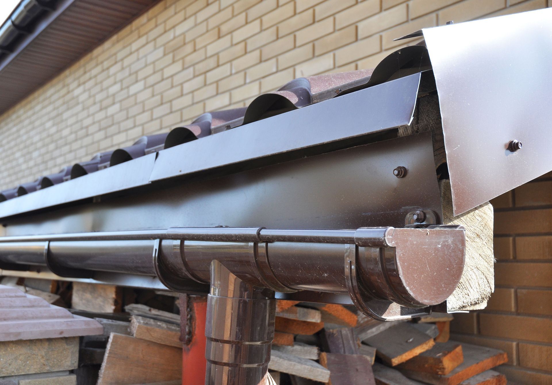 Brown gutter system attached to a brick building's roof.