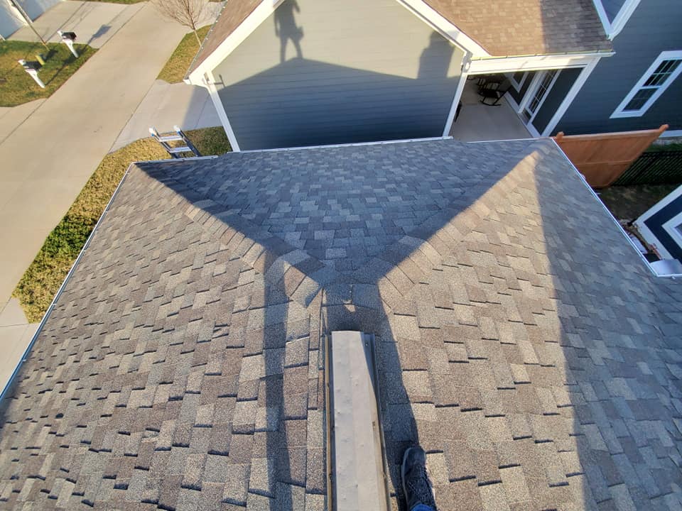 An aerial view of a roof with a shadow of a person on it.