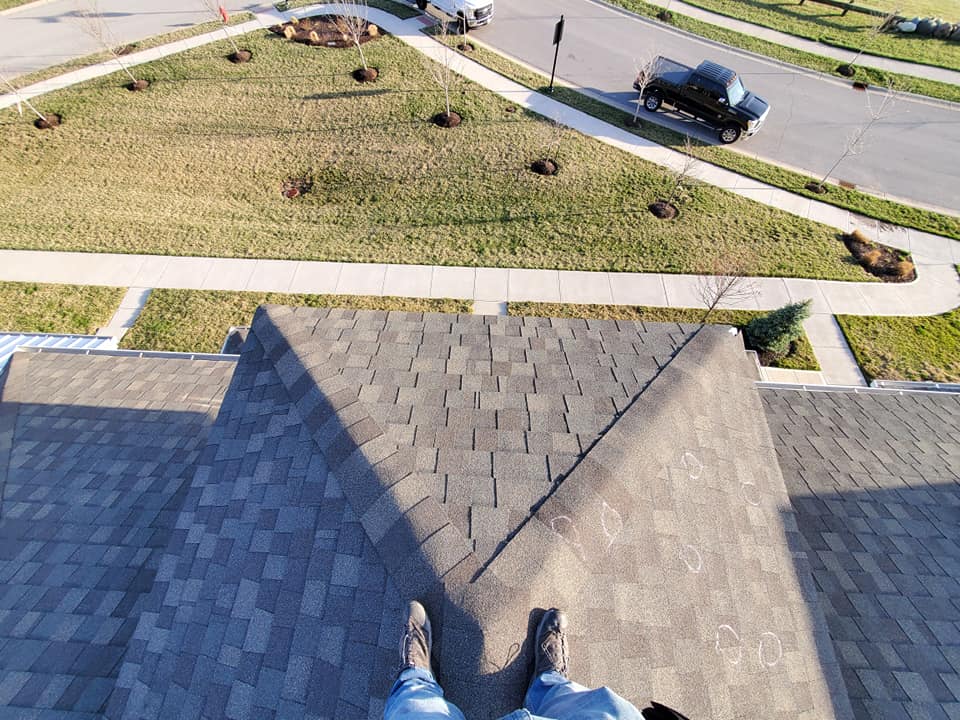 A person is standing on the roof of a house.