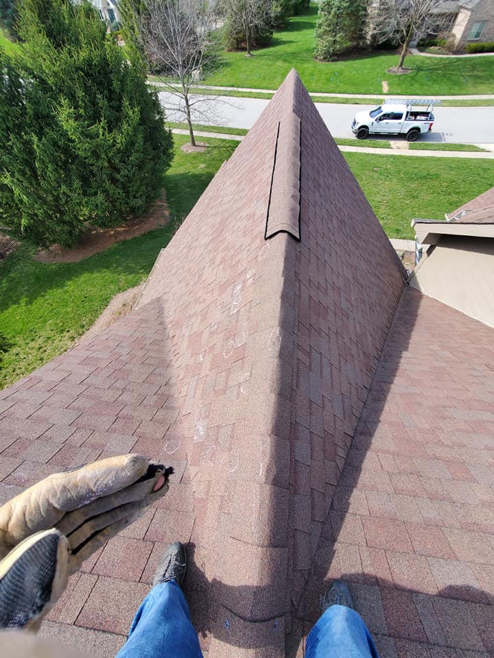 A person is standing on top of a roof that looks like a pyramid.