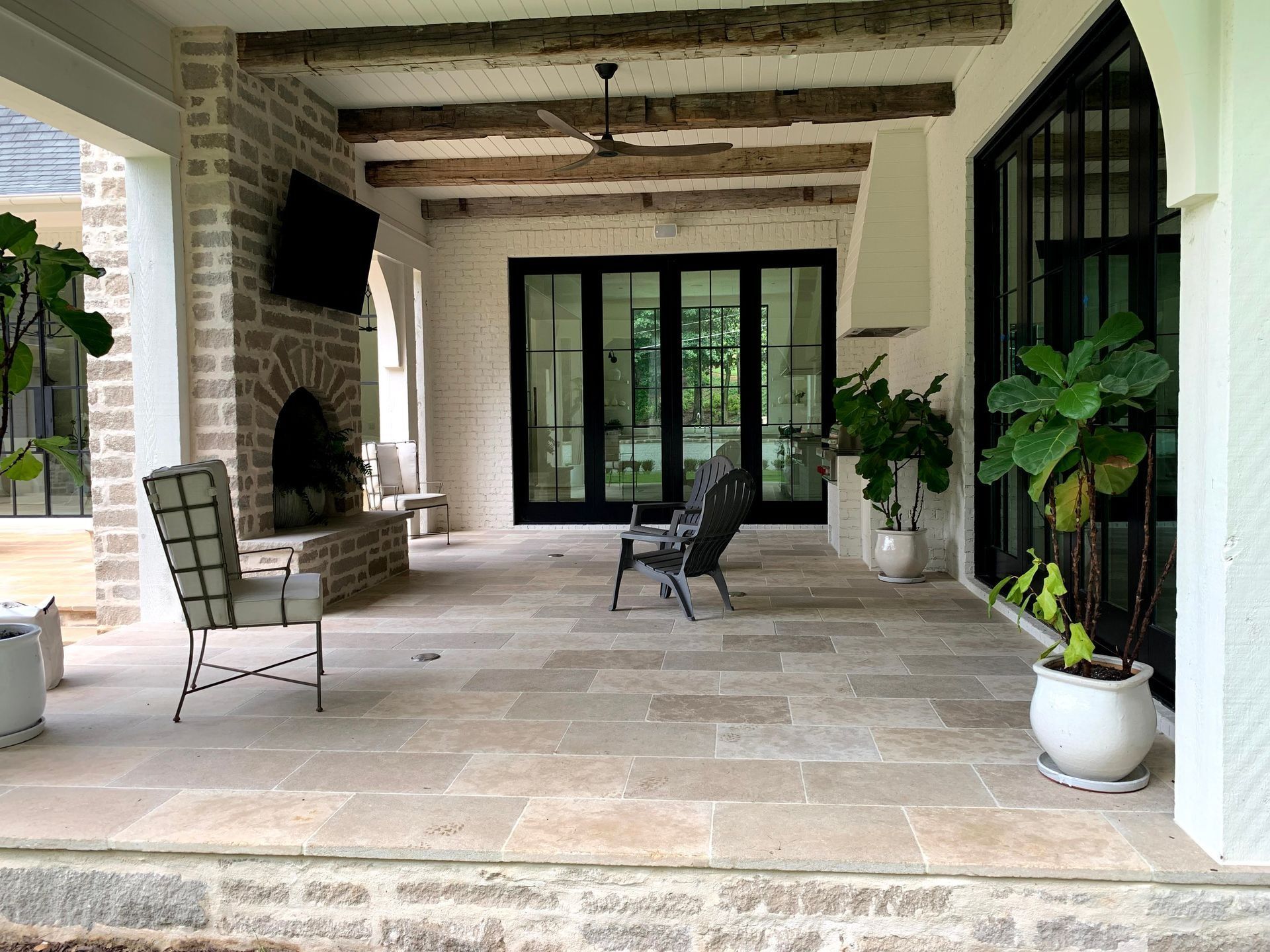 Outdoor patio with pergola, lounge chairs, fire pit, waterfall, and pool.
