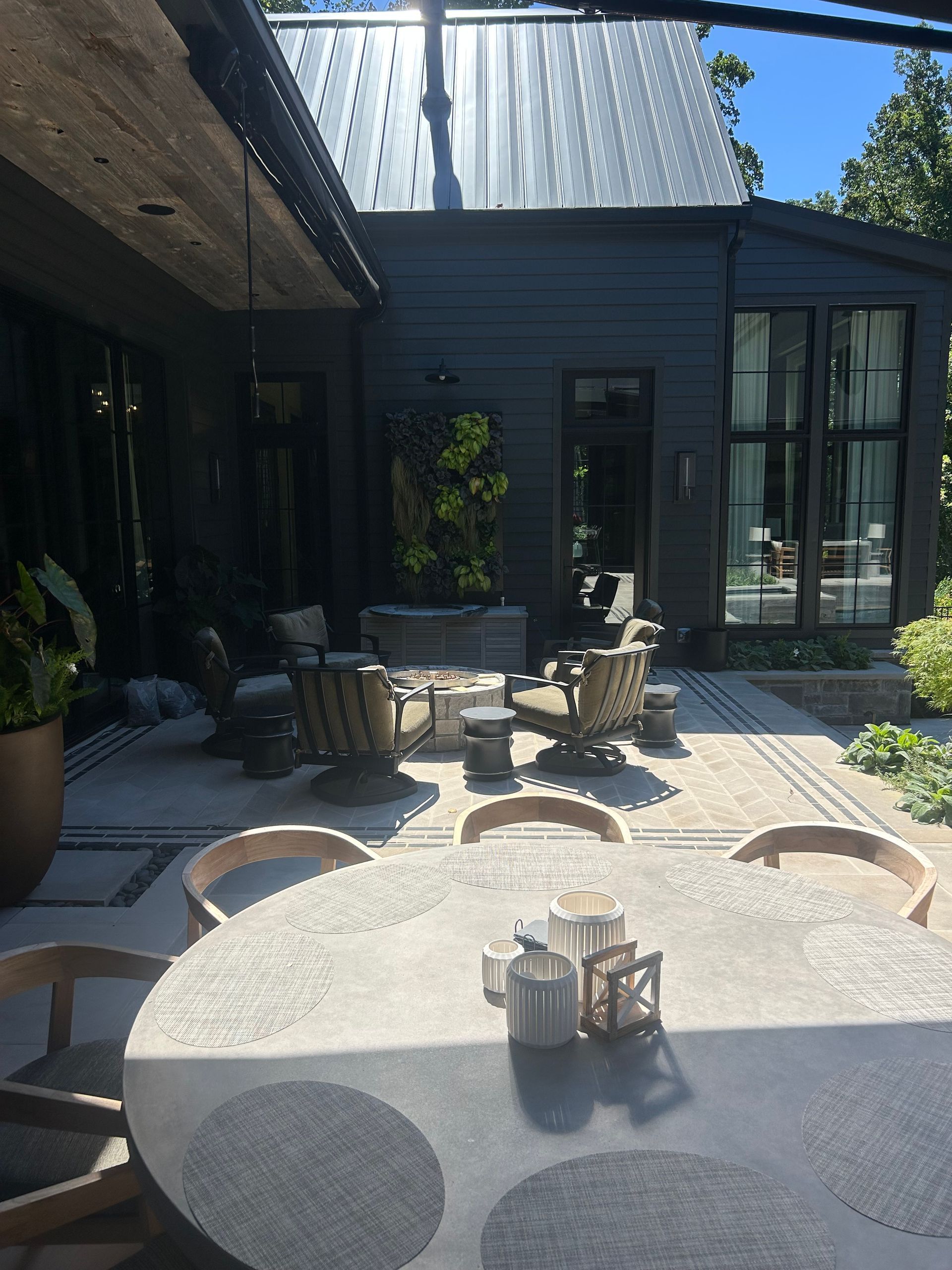 Outdoor patio with gray furniture, a round table, and a dark exterior.