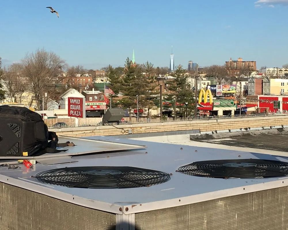 Rooftop view of cityscape with McDonald's, red buildings, and two circular fan vents.