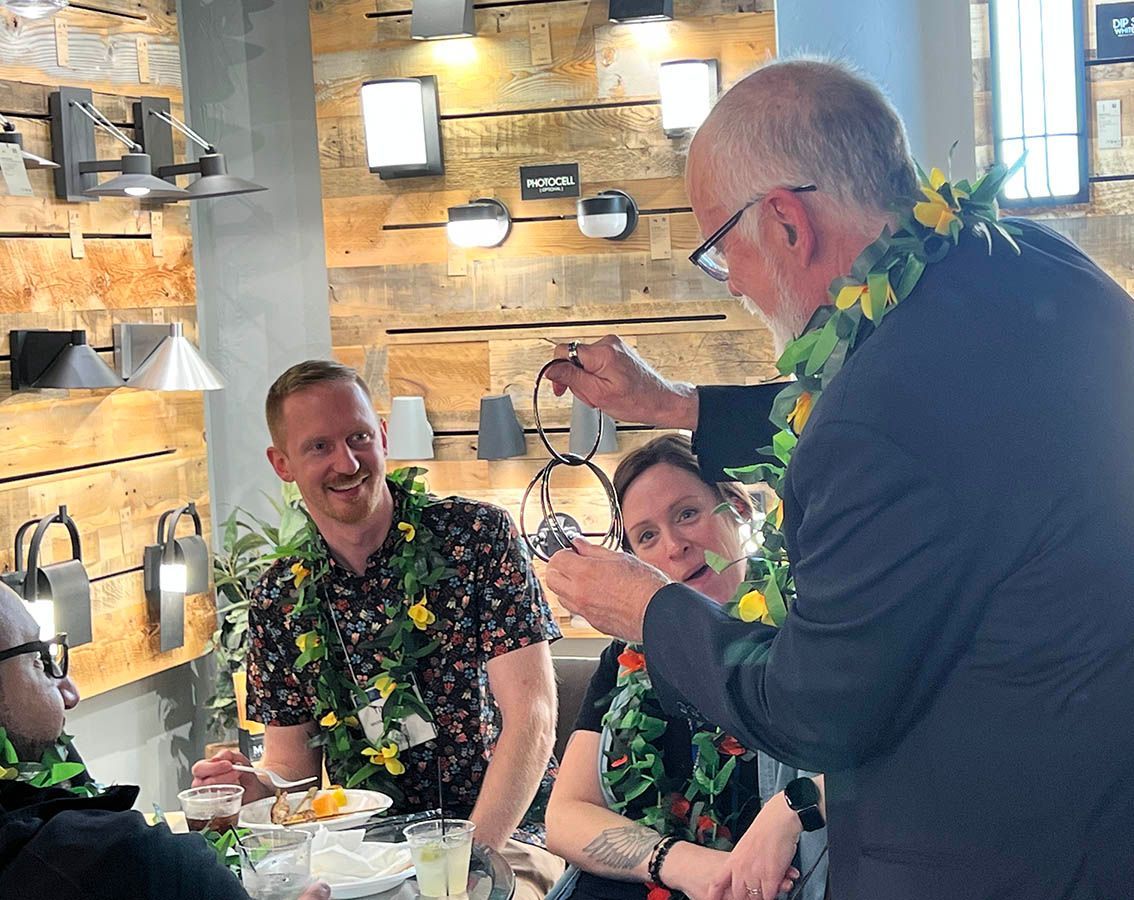 A man in a suit is standing in front of a group of people.