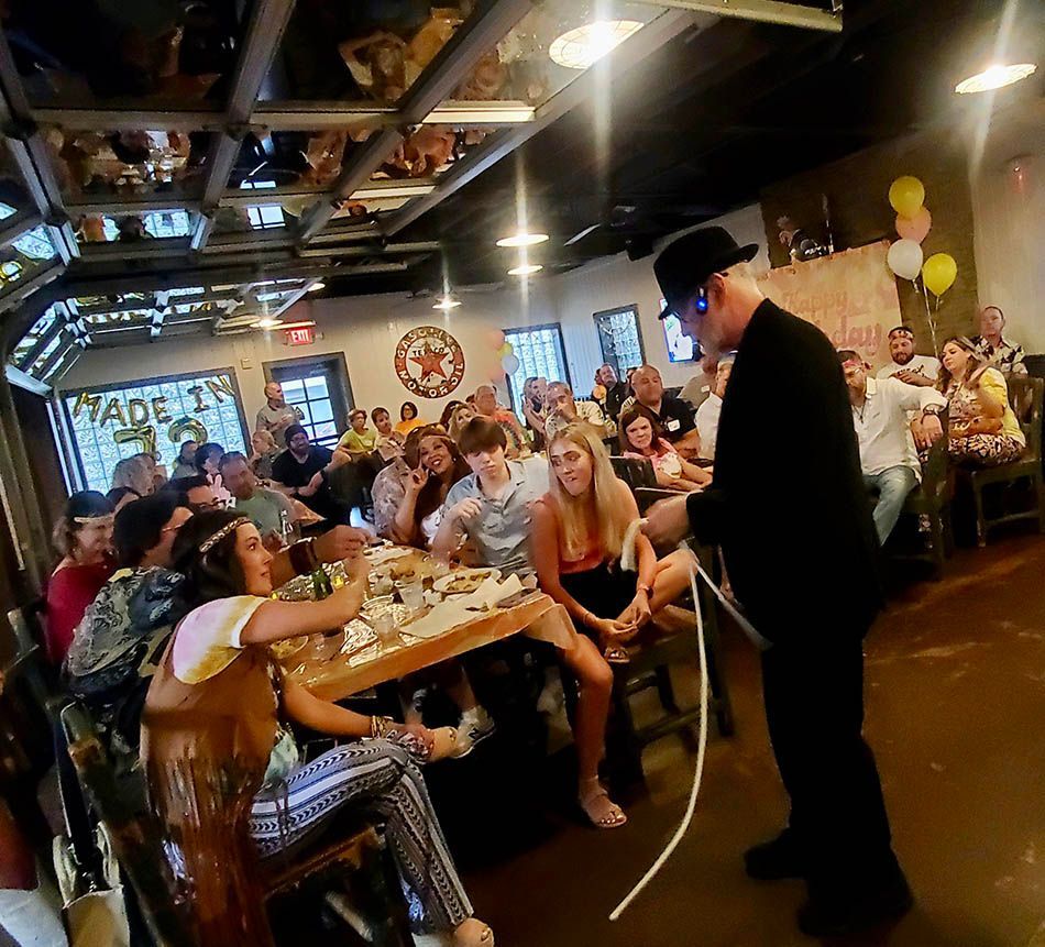 A man in a top hat stands in front of a crowd of people.
