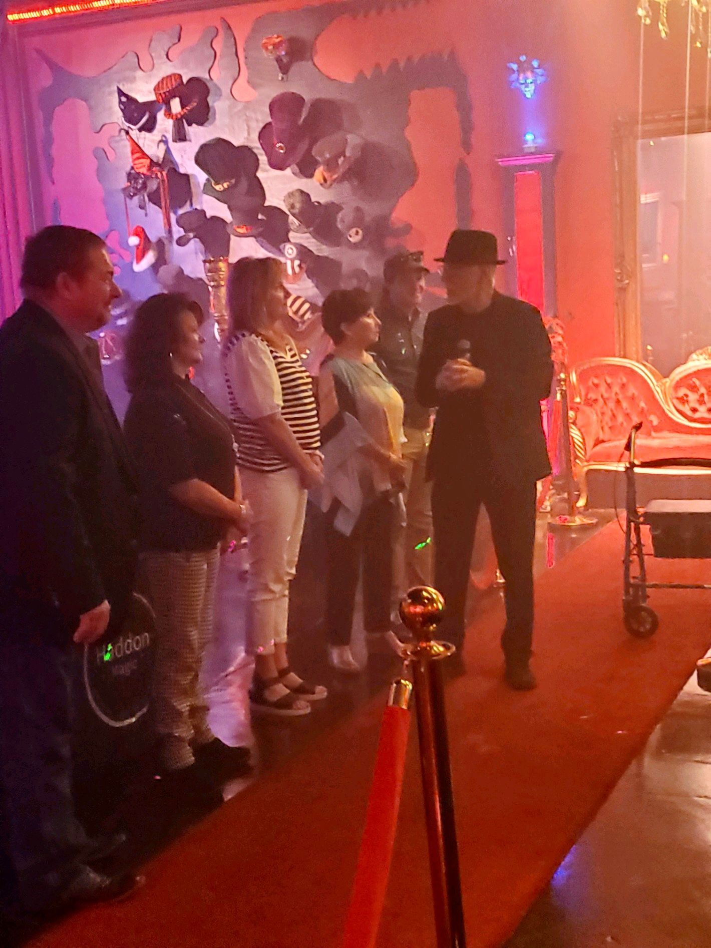 A group of people are standing on a red carpet.