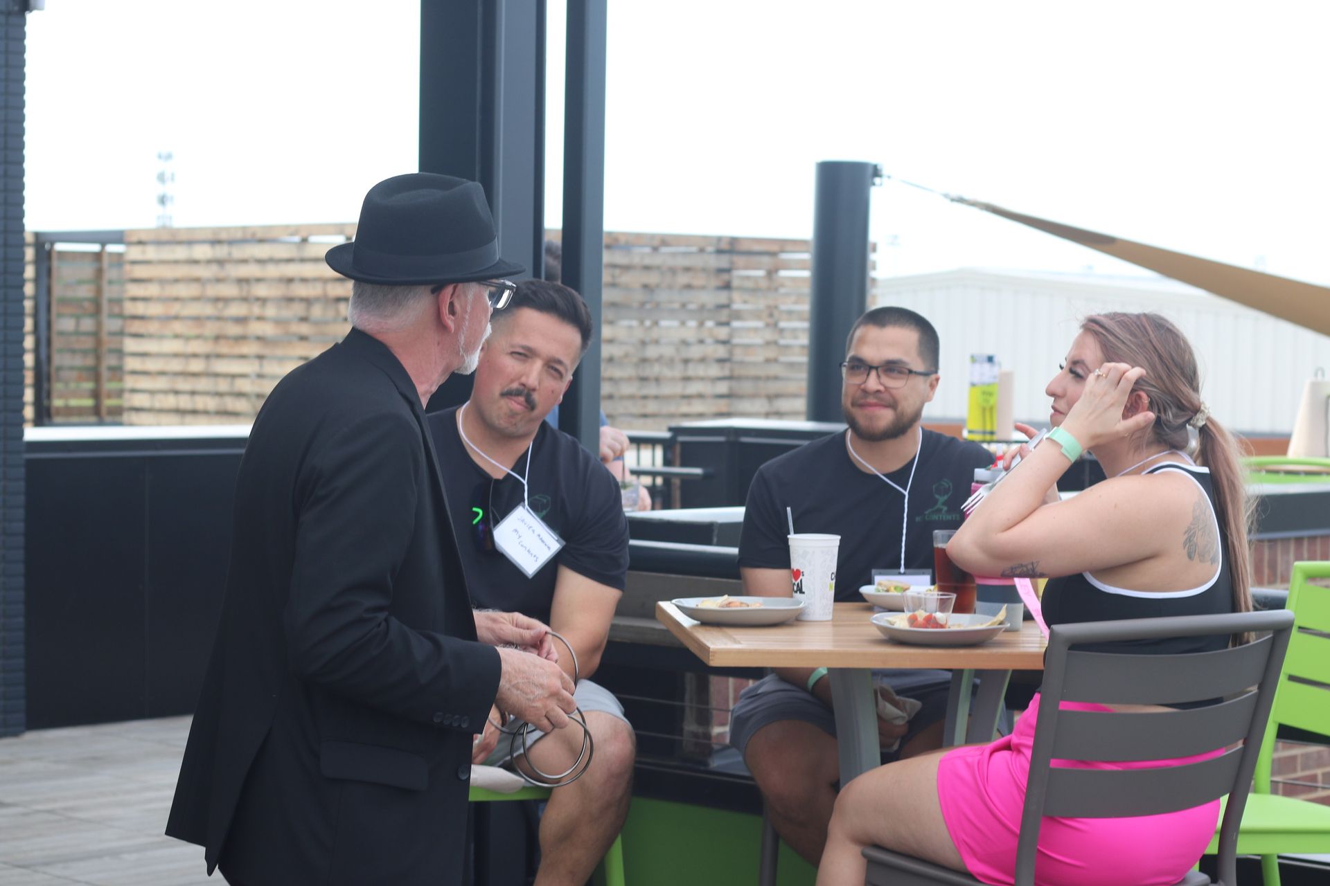 A group of people are sitting at a table talking to each other.