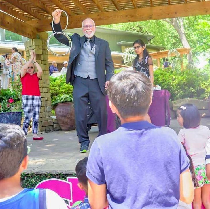 A man in a suit is holding a ring in front of a crowd of people.